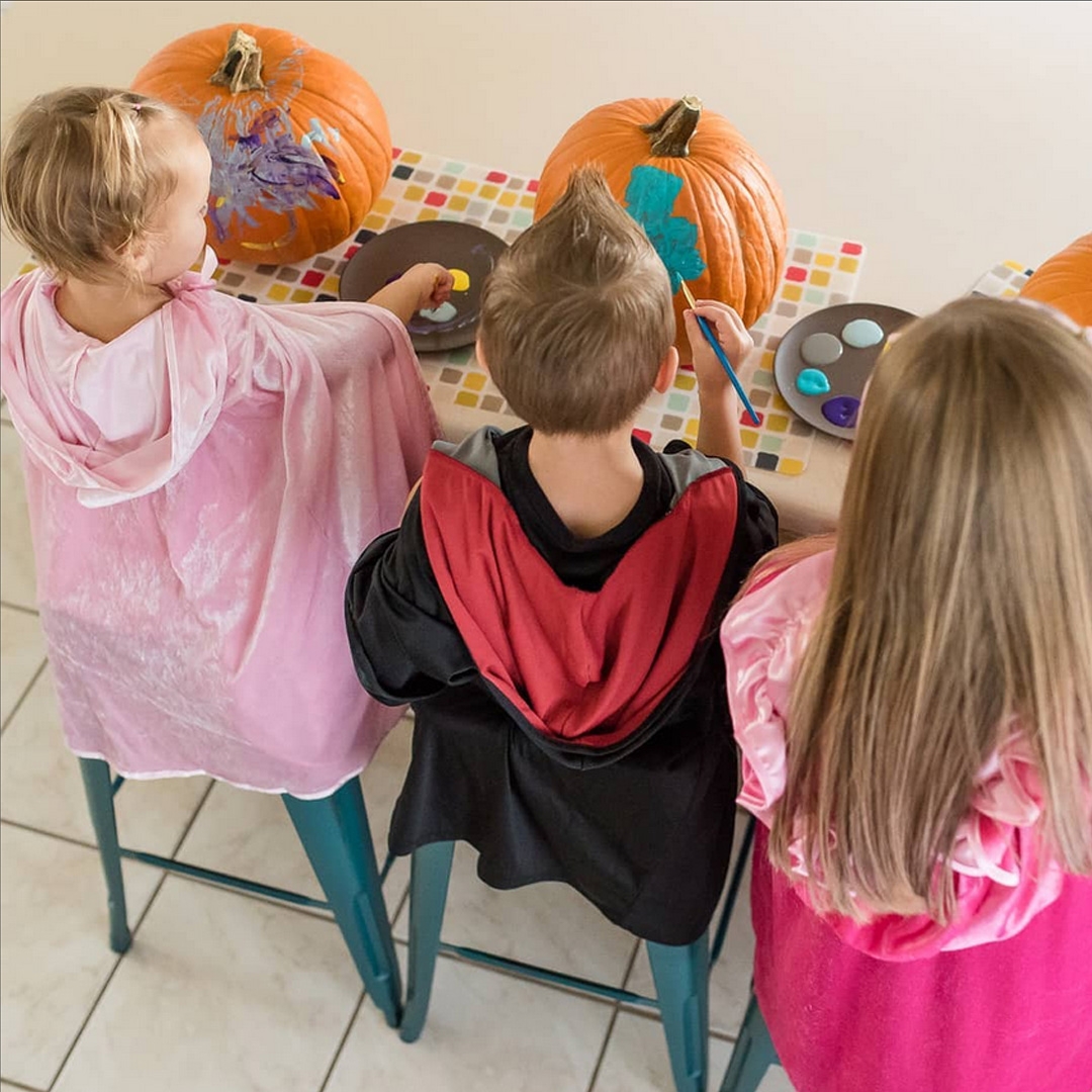 Kids verven pompoenen in halloween kostuums voor het Halloween feest
